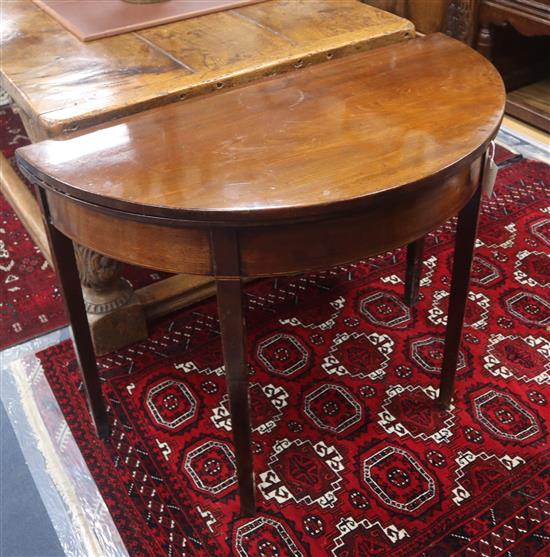 A George III mahogany D shaped folding tea table, with boxwood line inlaid frieze, W.94cm